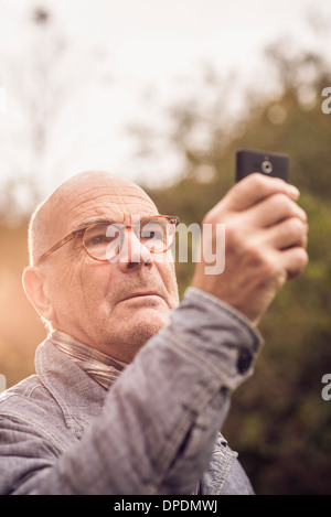 Senior uomo tramite telefono cellulare Foto Stock