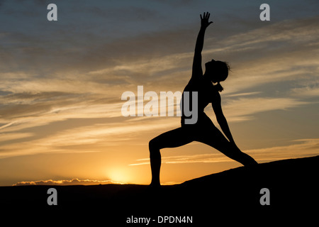 Silhouette di donna giovane fare yoga, Moab, Utah, Stati Uniti d'America Foto Stock