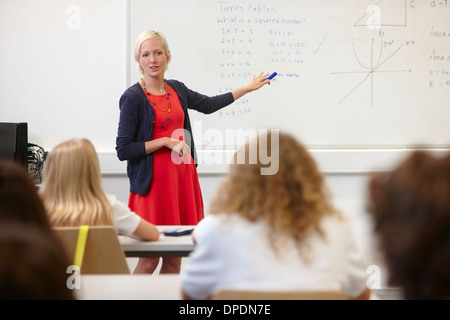 Insegnante femminile utilizzando la scheda bianco nella parte anteriore della classe Foto Stock