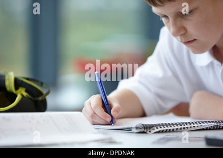 Close up schoolboy iscritto nella classe Foto Stock