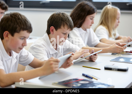 Fila di alunni lavorano in classe Foto Stock