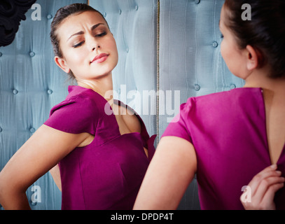 Giovane donna cercando sul vestito Foto Stock