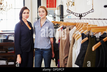 Giovani donne in piedi nel negozio di abbigliamento Foto Stock