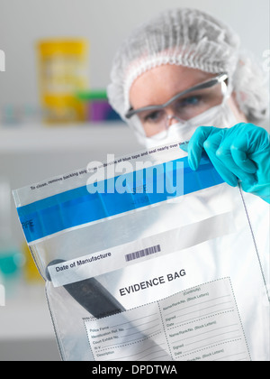 Lo scienziato forense holding prove sacco dalla scena del crimine in laboratorio Foto Stock