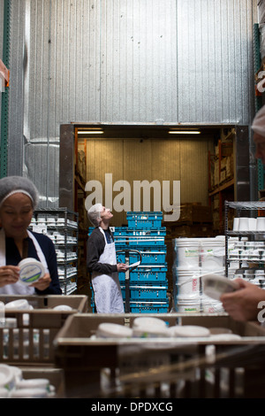 Lavoratori in fabbrica il controllo dei prodotti in magazzino Foto Stock