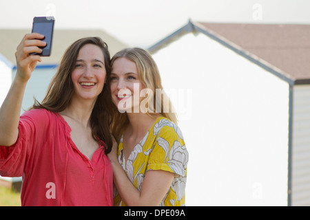 Due giovani amici di sesso femminile prendendo autoritratto, whitstable kent, Regno Unito Foto Stock