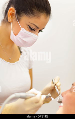 Dentista femmina lavorando su paziente Foto Stock