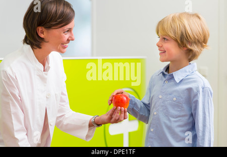 Dentista dando boy apple in ricezione dentale Foto Stock