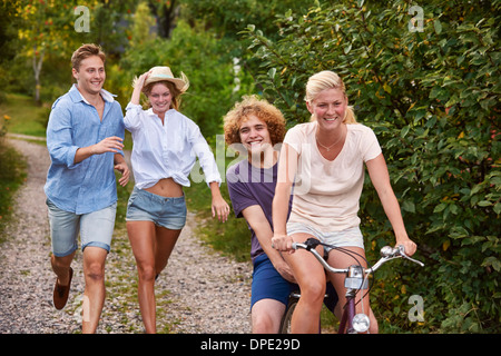 Due giovani coppie che si rincorrono sulla bicicletta, Gavle, Svezia Foto Stock