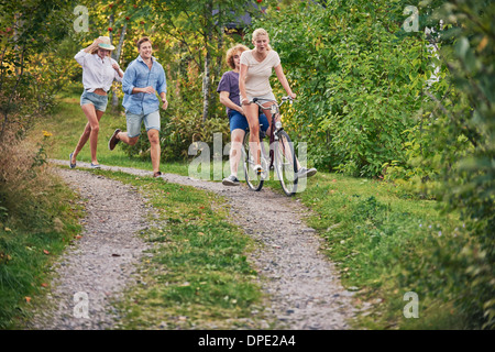 Due giovani coppie che si rincorrono lungo la pista sterrata, Gavle, Svezia Foto Stock