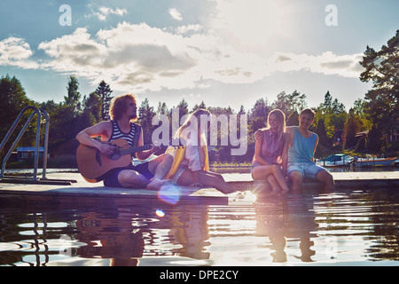 Due giovani coppie relax su Pier, Gavle, Svezia Foto Stock