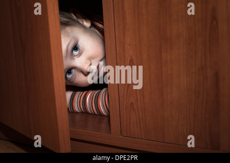 Paura bambino ragazzo nascosto in un armadio Foto Stock