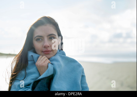 Giovane donna avvolta in una coperta Foto Stock