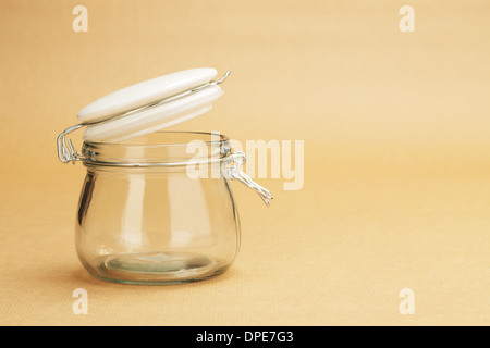 Un vaso vuoto con un coperchio bianco su uno sfondo di una carta di avvolgimento Foto Stock