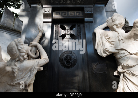Cimitero di Recoleta José C Paz Mausoleo Buenos Aires // BUENOS AIRES, Argentina — l'elaborato mausoleo di José C. Paz, fondatore del giornale la Prensa, espone il lavoro dello scultore francese Jules Félix Coutan nel cimitero di Recoleta (Cementerio de la Recoleta). Creata nel 1904, la tomba presenta elementi scultorei drammatici, tra cui angeli a grandezza naturale e immagini simboliche che rappresentano la partenza dell'anima, riflettendo la grandezza dell'arte funeraria della Belle Époque. Foto Stock