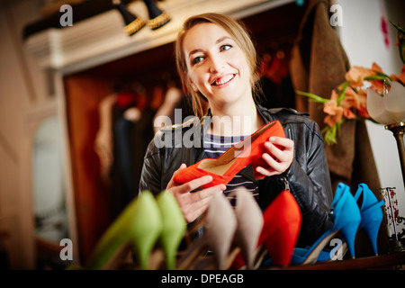 Giovane donna che guarda la selezione di alta scarpe con tacco Foto Stock