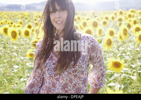 Metà donna adulta in un campo di girasoli Foto Stock