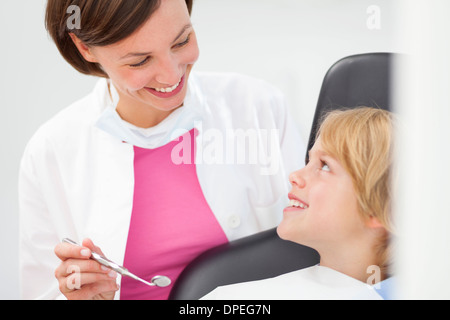 Ragazzo avente check up, dentista azienda specchio dentale Foto Stock