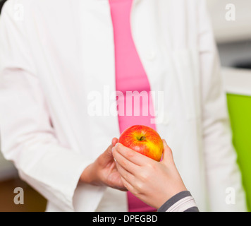 Dentista dando ragazza apple, close up Foto Stock