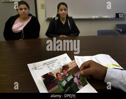 (Pubblicato il 29/09/2003, B-1) Ex Lincoln High School studenti Brenda Barron, 15, sinistro e Maricela Zamora, 16, sedersi di fronte al loro ex principale Wendell Bass come egli guarda una foto che lui ha dato del Maricela e sua sorella Nadia Zamora, 18, nel loro Lincoln High School soccer uniformi. Le ragazze hanno avuto la visita del suo ex principale nell'ufficio della loro nuova scuola- P Foto Stock