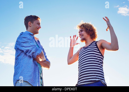 Due amici maschi godendo di conversazione in presenza di luce solare Foto Stock