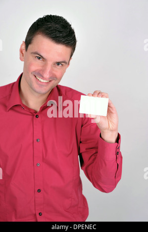 Uno bianco brown bello uomo sorridente contiene carta bianca per messaggi commerciali sul copyspace, egli è positivo e guardare fiduciosi Foto Stock