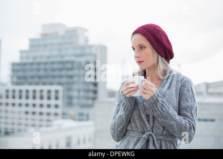 Pensare una splendida bionda di bere il caffè all'aperto Foto Stock