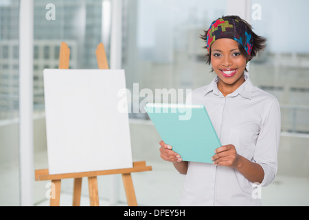 Sorridente donna artistico azienda blocco schizzi Foto Stock