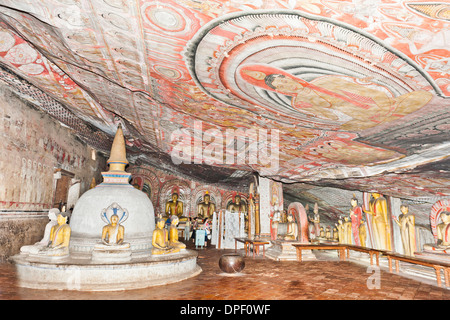 Interamente dipinta camera interna della grotta, colorati murali sulle pareti e il soffitto, affreschi, statue e uno stupa Foto Stock