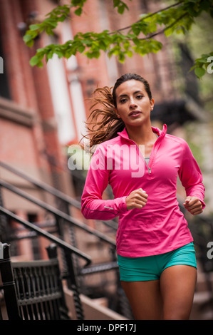 Donna jogging sul marciapiede Foto Stock