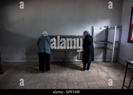 Il Cairo, Egitto. Xiv gen, 2014. Gli elettori riempire le loro schede elettorali in corrispondenza di una stazione di polling nella città di Nasr, il Cairo, Egitto, 14 gennaio 2014. Gli egiziani ha iniziato la colata i loro voti su Martedì sul paese del nuovo progetto di costituzione che è ampiamente considerato come una pietra miliare nel corso dell'Egitto transizione politica dopo il presidente islamista Mohamed Morsi era stato estromesso nel luglio scorso. Credito: Amru Salahuddien/Xinhua/Alamy Live News Foto Stock