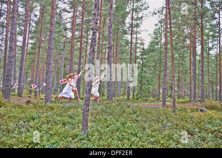 Le ragazze adolescenti in esecuzione nella foresta con aquiloni Foto Stock