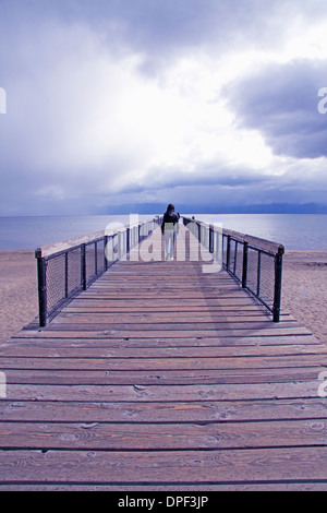 Giovane uomo in lontananza sul molo, Lake Tahoe, Nevada, STATI UNITI D'AMERICA Foto Stock