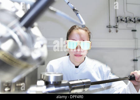 Donna scienziato operativo apparecchiature scientifiche Foto Stock