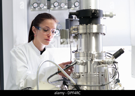 Donna scienziato operativo apparecchiature scientifiche in laboratorio Foto Stock