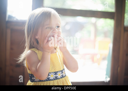 Close up toddler femmina con Mani sulla bocca Foto Stock