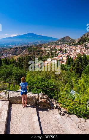 Tourist ammirando la vista sull'Etna dal teatro greco (teatro greco), Taormina, Sicilia, Italia, Europa Foto Stock