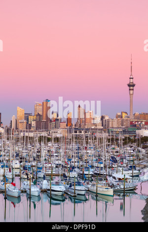 Westhaven Marina & skyline della città illuminata al tramonto, dal porto di Waitemata di Auckland, Isola del nord, Nuova Zelanda, Australasia Foto Stock