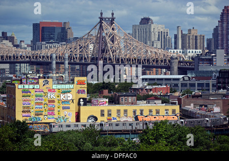 5 Pointz museo graffiti con la 59th Street Bridge e la skyline di Manhattan in background e la metropolitana in primo piano. Foto Stock