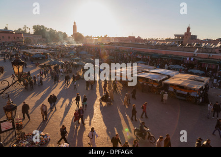 La vivace piazza di Piazza Jemaa el Fna con il minareto della Moschea Koutoubia in distanza, sito UNESCO, Marrakech, Marocco Foto Stock