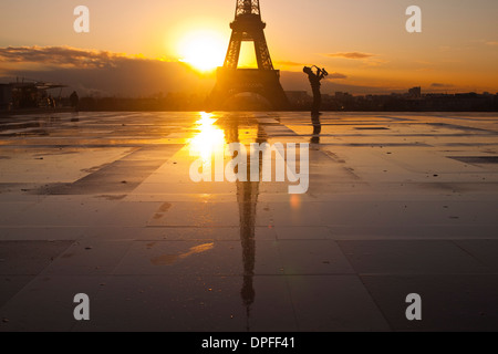 Un uomo suonare la tromba davanti alla Torre Eiffel, Parigi, Francia, Europa Foto Stock