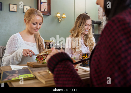 Giovani amici di sesso femminile avente il cibo insieme Foto Stock