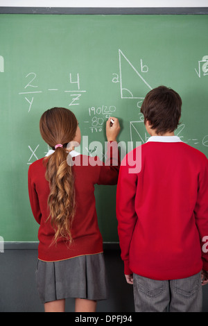 Gli studenti adolescenti risolvere la matematica a bordo Foto Stock