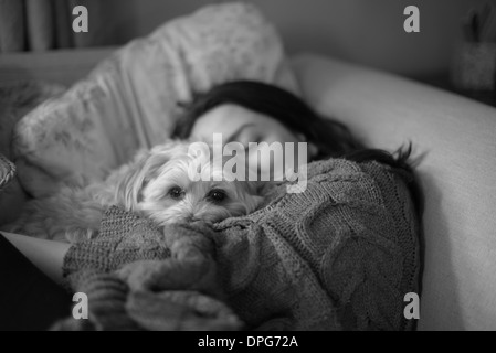 Napping ragazza wiith piccolo cane in bianco e nero Foto Stock