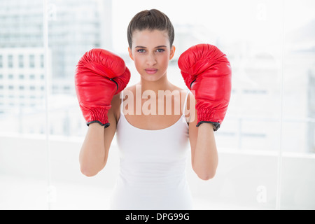 Stern marrone naturale donna dai capelli in bianco sportswear indossando guanti di inscatolamento Foto Stock