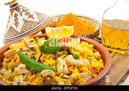 La paella con zafferano e olio su una tavola di legno su bianco Foto Stock