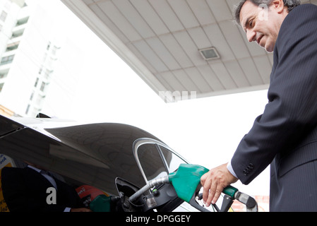 Imprenditore il rifornimento auto presso la stazione di gas Foto Stock