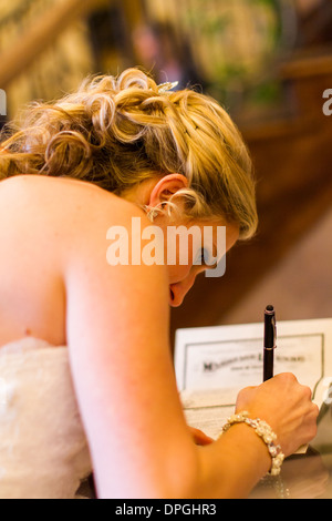 Sposa la firma di licenze di matrimonio dopo la cerimonia. Foto Stock