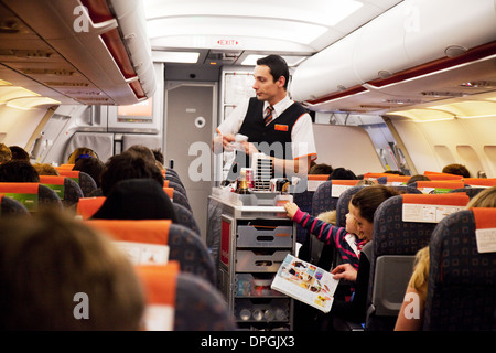 Equipaggio di cabina easyJet: Personale addetto al volo della linea aerea easyJet in aereo che serve cibo e bevande come pasto per i passeggeri Foto Stock