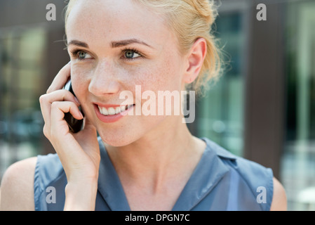 Giovane donna fare chiamate tramite smartphone Foto Stock